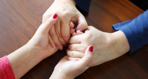 Two sets of hands holding each other.