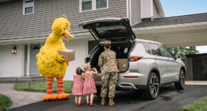 Big Bird helping a family pack the car.