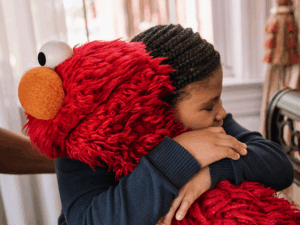 Elmo and a child hugging