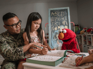Elmo and a family reading.